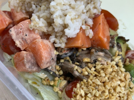밥, 연어, 방울토마토, 양상추, 볶은 마늘, 버섯 등이 담긴 샐러드