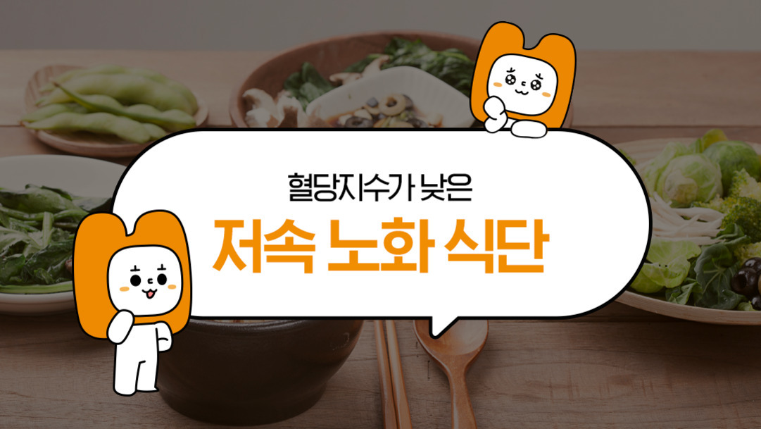 식탁 위에 다양한 채소 요리가 놓여 있고, 중앙 말풍선에 '혈당지수가 낮은 저속 노화 식단'이라는 문구와 귀여운 캐릭터 두 마리가 그려져 있다.