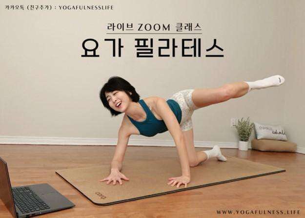 요가 매트 위에서 한 여성이 요가 필라테스 동작을 하며 노트북을 바라보고 있다. 배경에는 식물과 장식품이 놓여 있다. 상단에는 '라이브 ZOOM 클래스 요가 필라테스'라는 문구가 적혀 있다.